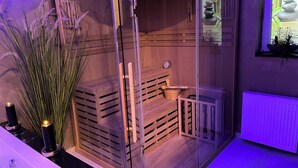 Eine Sauna mit Holzvertäfelung, einer Glastür und einer Uhr an der Wand.