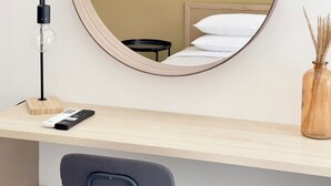 A round mirror on a wall, a desk with a lamp, a chair, and a vase with dried plants. - Seagull by halu! (Katerini)