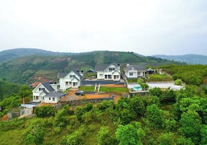 A residential area with houses on a hillside, featuring a central staircase leading to a shared roof space. - Mount Tales Vagamon (Peermade)