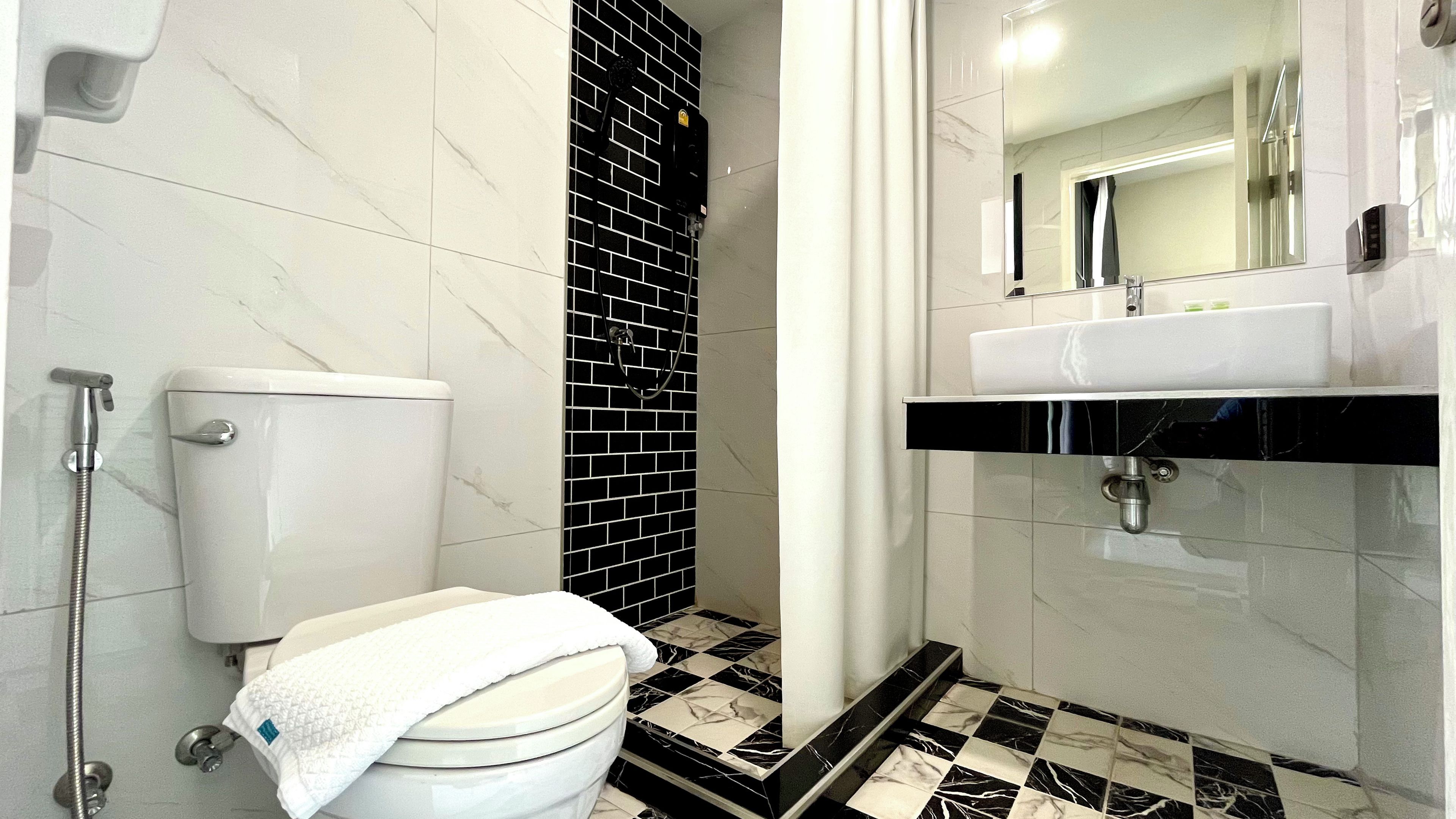 A bathroom with a toilet, a shower, and a sink.
