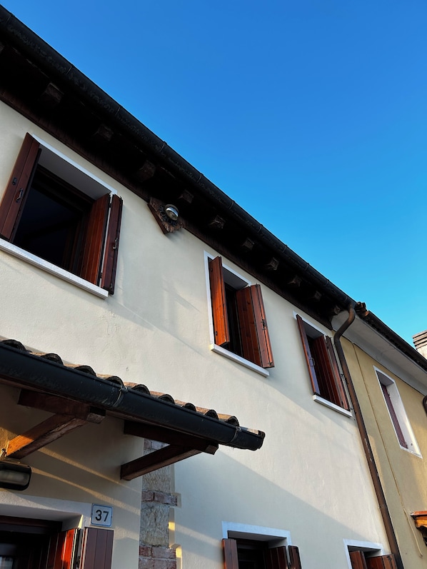 Un bâtiment doté de nombreuses fenêtres, avec un panneau indiquant clairement le numéro « 37 », et un ciel bleu dégagé.