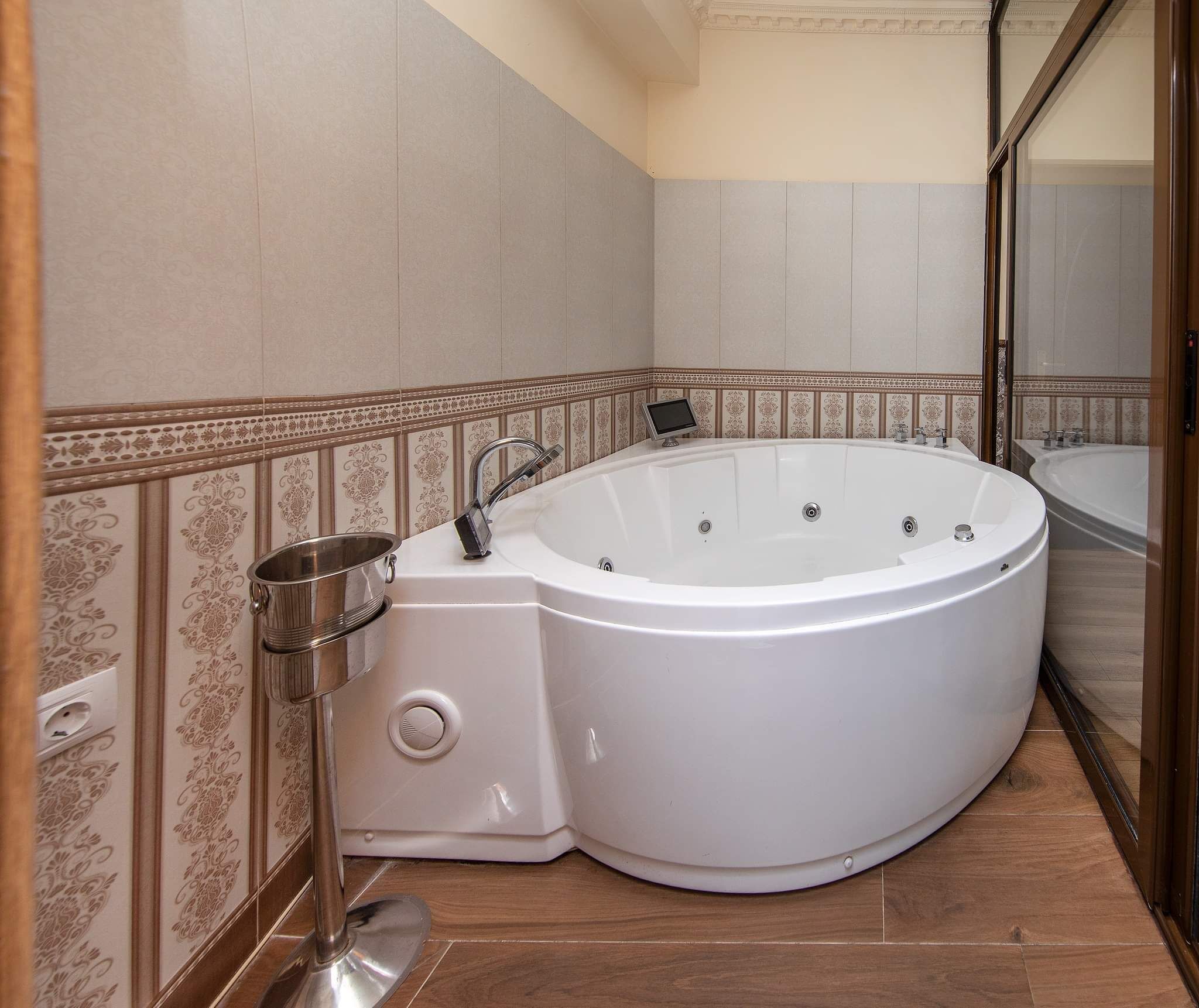 Un baño moderno con una amplia bañera independiente, un lavamanos empotrado y un espejo.