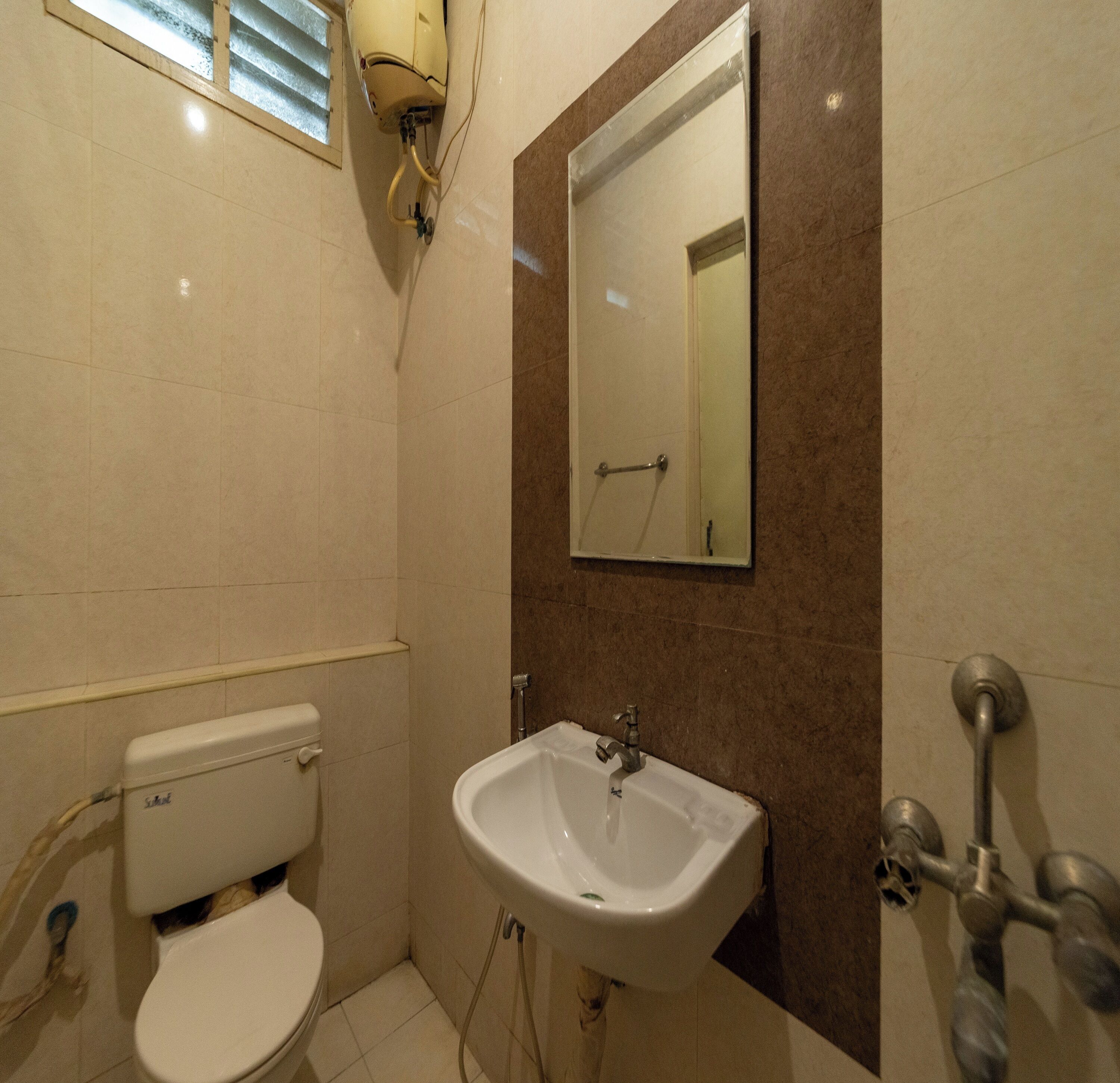 Un baño pequeño con inodoro, lavabo y espejo.