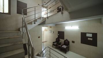 A multi-level interior with a staircase, seating area, and wall-mounted signs.