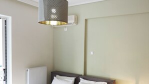 A neatly made bed with white and pink towels, a bedside lamp, and a small bedside table with a book. - Luminous Penthouse big veranda by GHH (Athens)