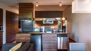 Una cucina moderna dotata di lavastoviglie, frigorifero, microonde e macchina del caffè.