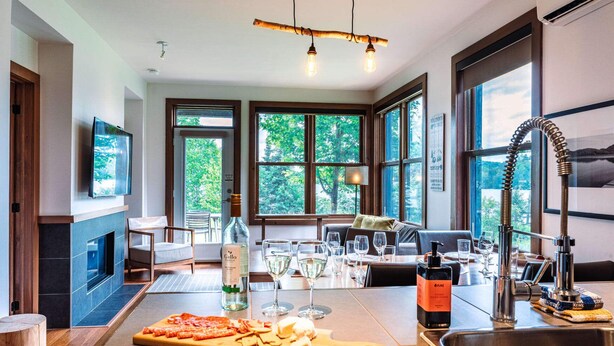 Una cocina moderna con una isla grande, copas de vino y una botella.