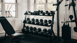 A gym with a bench, dumbbells, and exercise equipment. - Lakefront & Mountain View - 1 Bedroom Resort Suite (Lac-Supérieur)
