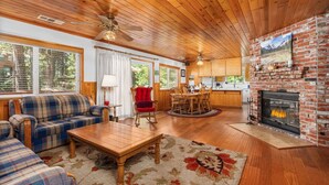A cozy living room with a plaid sofa, wooden coffee table, and a fireplace. - Rustic retreat in a convenient location! (Shaver Lake)