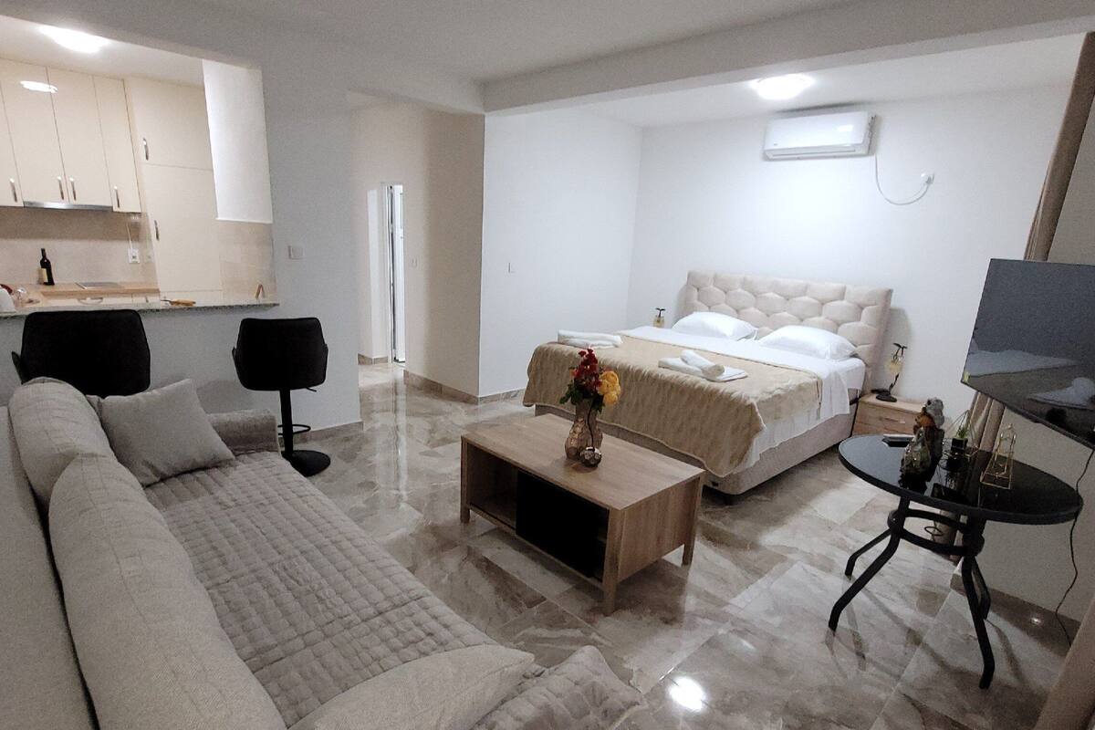 Et moderne hotelværelse med en stor seng, en sofa, et sofabord og et fjernsyn.