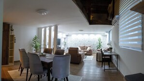 Un salón amplio con una mesa de comedor, sofás y una cocina al fondo.