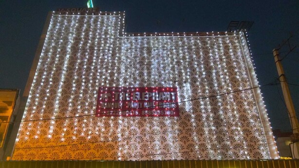 A building with a patterned facade and illuminated signage advertising 'The Elephant Restaurant' and 'Banquet Party Hall Rooms'. - The Elephant Hotel (Rohtak)