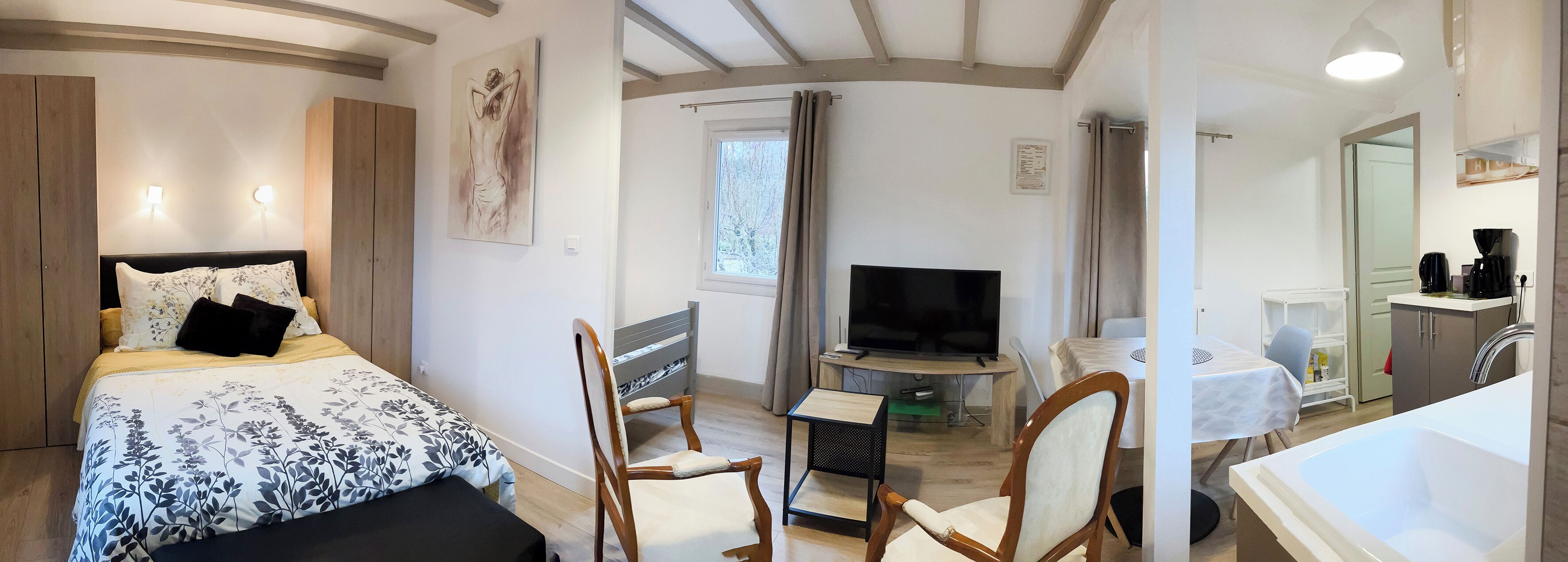 A bedroom with a bed, a TV, a desk, and a chair.
