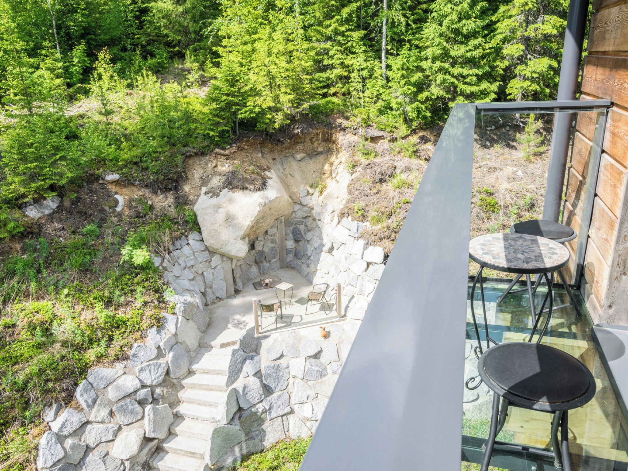 A stone staircase leading to a wooden deck with outdoor furniture.