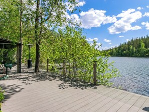 Une terrasse en bois offrant une vue sur un lac et une forêt.