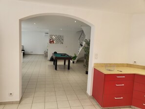 Spacious room with a pool table and arched doorway to a separate area.