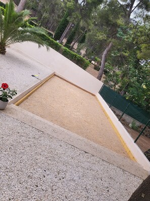 Enjoy the tranquil atmosphere on this rooftop terrace surrounded by lush greenery and a small sandpit.