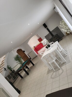 Enjoy meals together at the central dining table, with a separate kitchen area nearby.