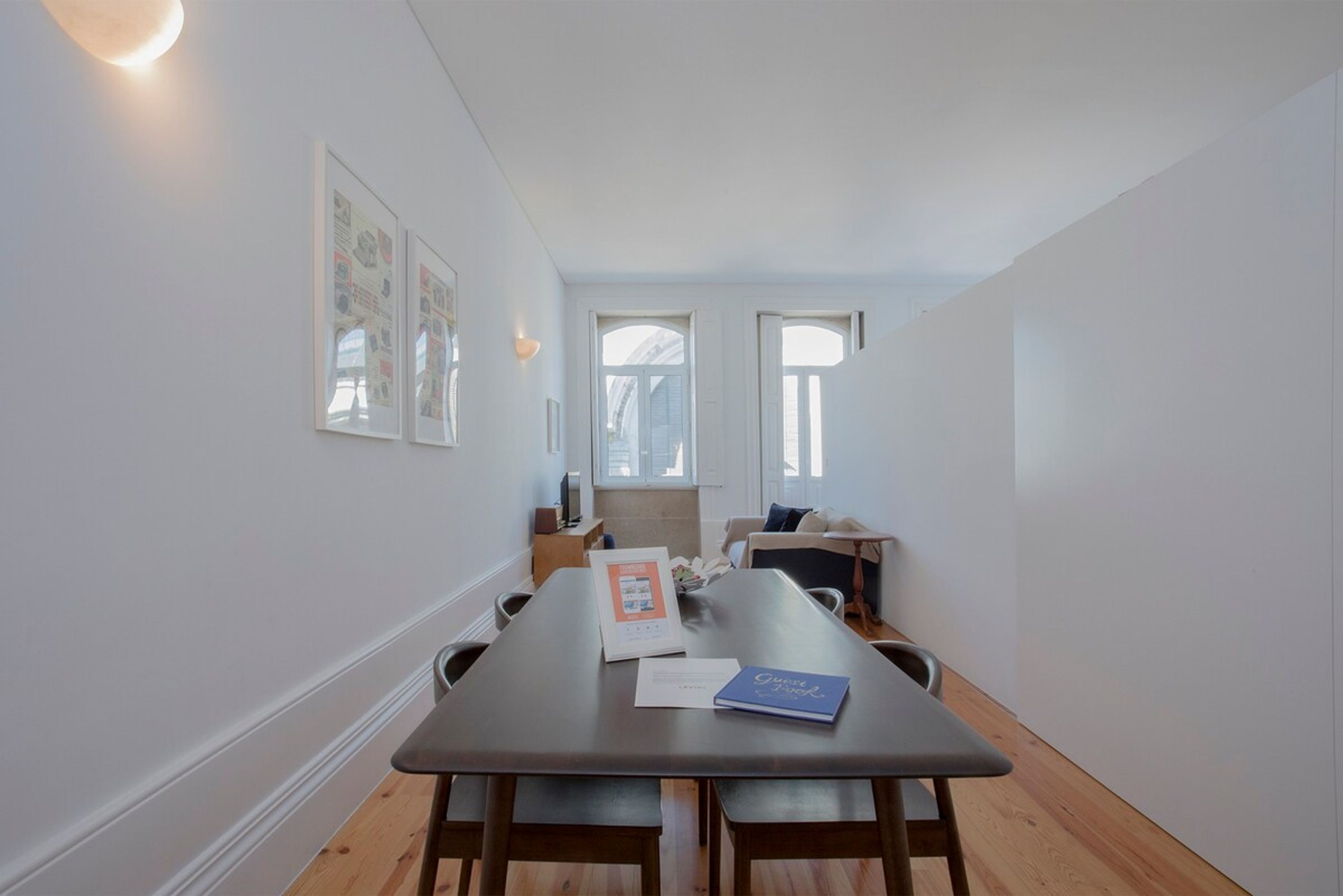 Een moderne eetruimte met een lange tafel, banken en lijstwerken aan de wanden.