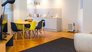 Une cuisine moderne avec des armoires blanches, un plan de travail noir et un four encastré.