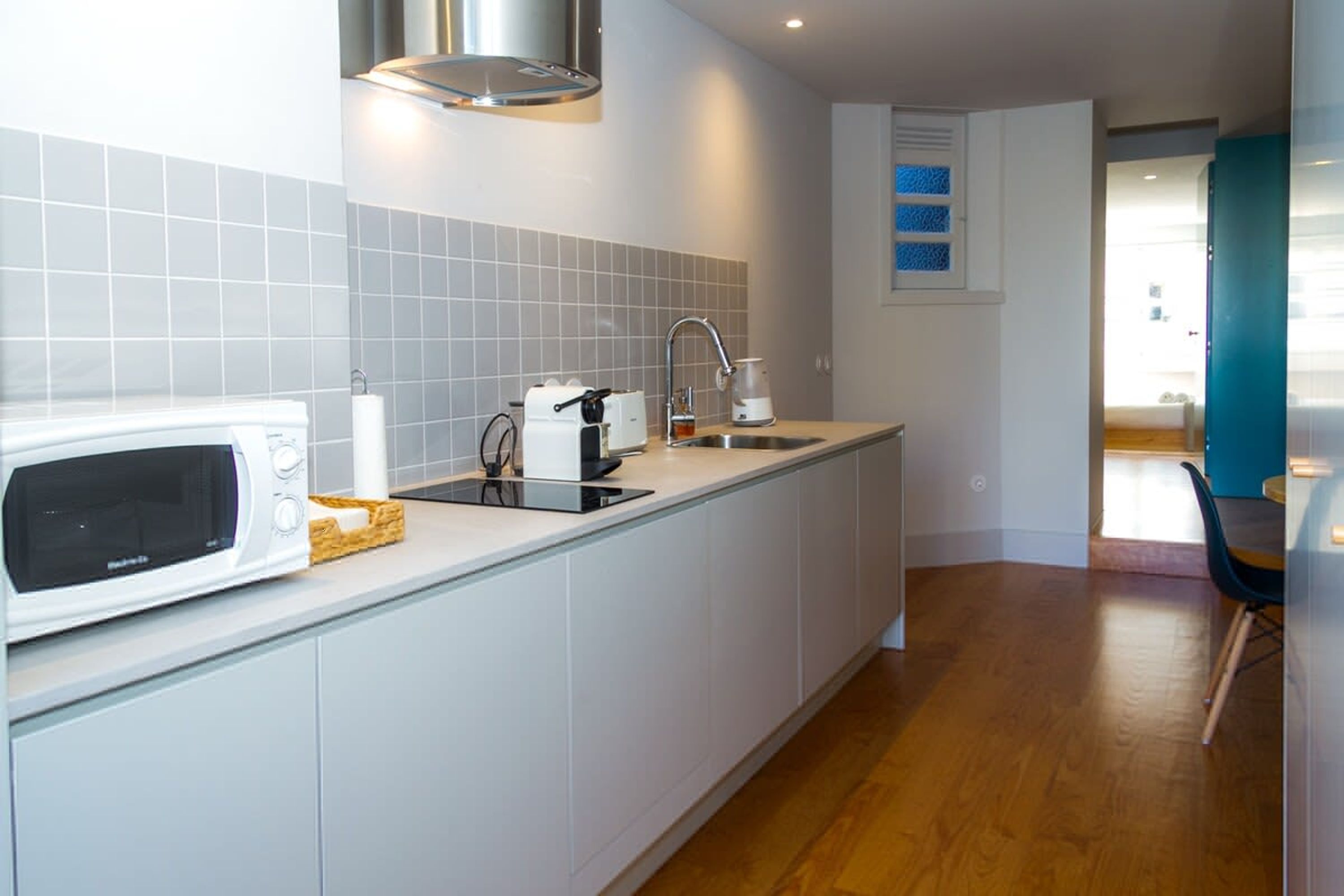 Una cocina moderna equipada con microondas, tostadora y lavamanos.