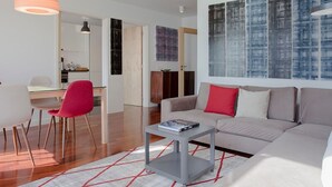 Un salon moderne comprenant un canapé, une table basse et un coin repas avec des chaises et une table.
