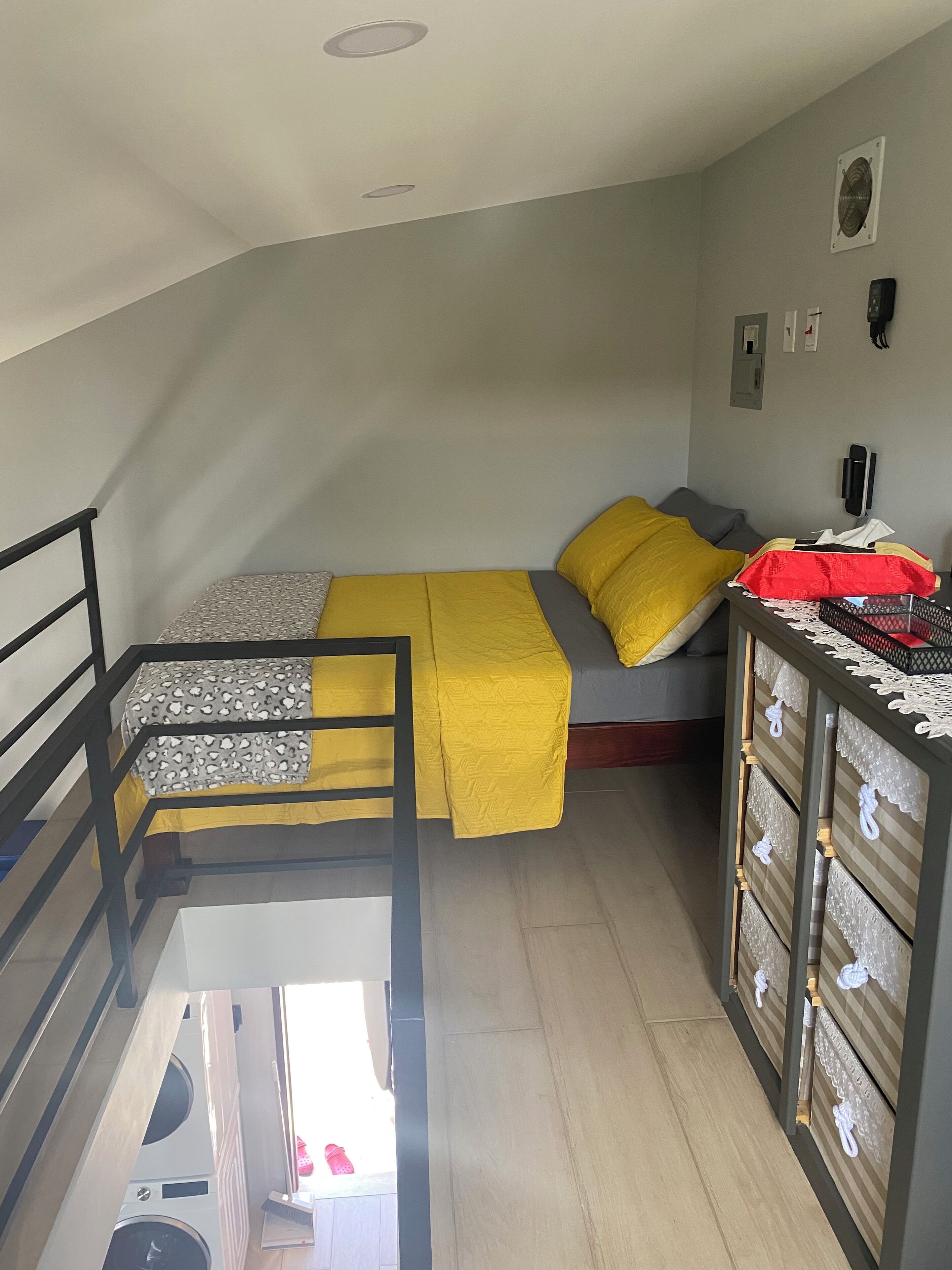 Una stanza piccola con un letto a castello, una scrivania e un telefono, oltre a un termosifone.