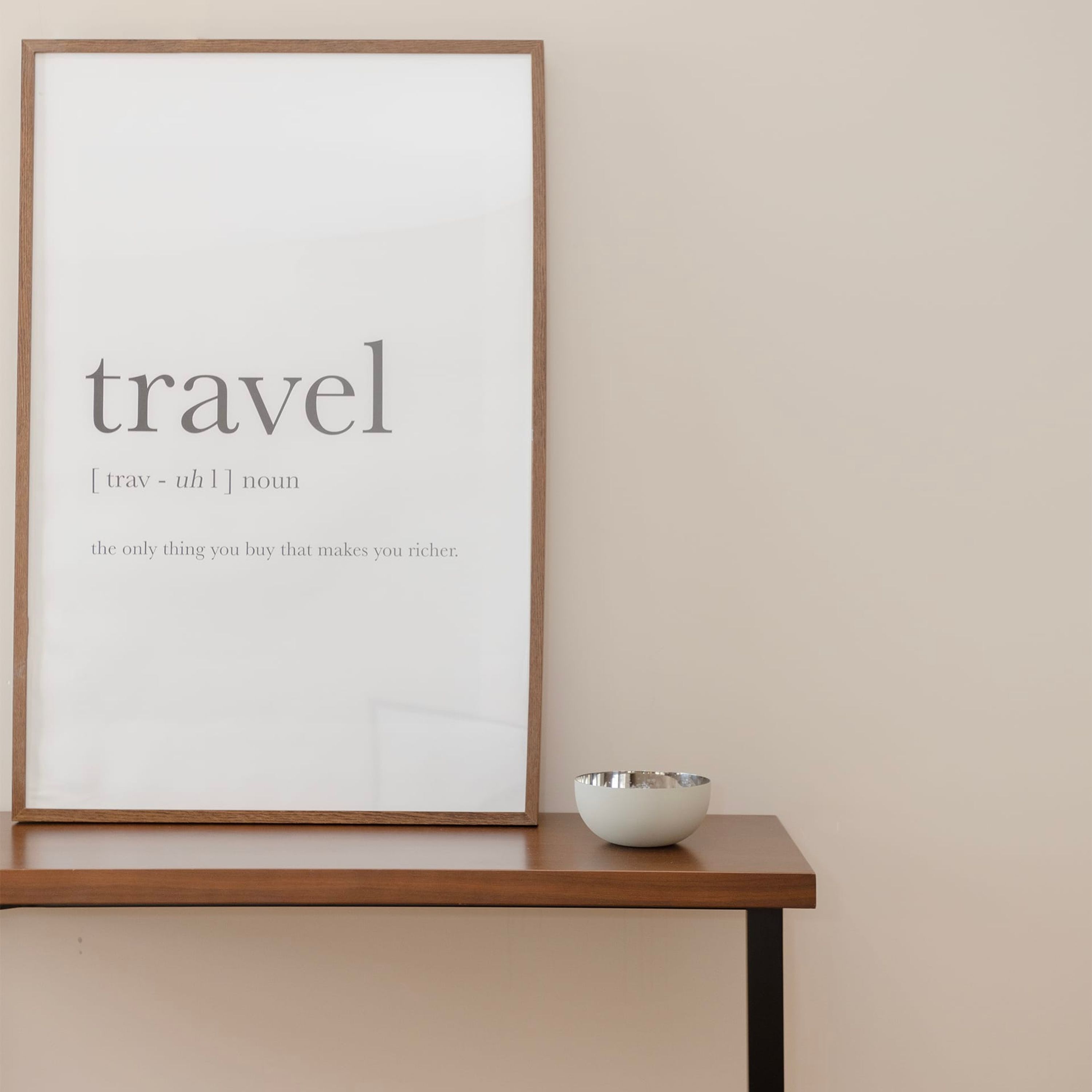 A framed word 'travel' with its definition and a quote on a wall.