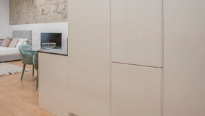 Eine moderne Küche mit Steinwand, einem Essbereich mit Tisch und Stühlen sowie einem hellen Boden.