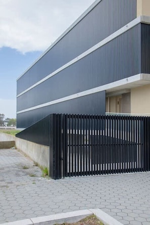 A modern building with a flat roof and a black metal fence in front. - Liiiving in Gaia - Beach Seaside Apartment (Vila Nova de Gaia)