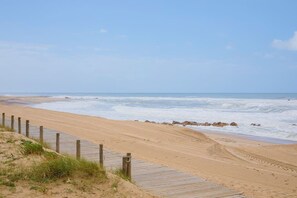 A sandy beach with a wooden boardwalk and a clear sky. - Liiiving in Gaia - Beach Seaside Apartment (Vila Nova de Gaia)