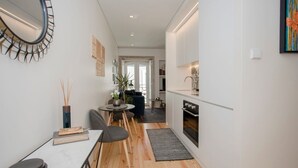Une cuisine moderne avec un coin repas, un plancher en bois et une vue sur le salon.