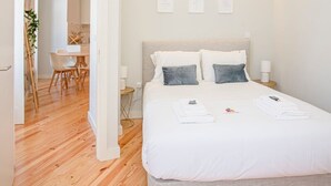 Una camera da letto moderna con un letto grande, comodini e un angolo studio con sedie.