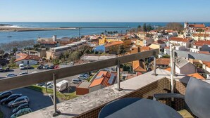 Paesaggio costiero con vista chiara sul mare e un edificio importante con tetto rosso.