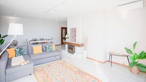 Un soggiorno moderno con un divano grigio, un tappeto decorato e un tavolino con una pianta.