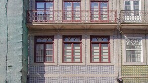 Un immeuble à plusieurs étages, doté de balcons, de fenêtres à motifs et d’une façade recouverte de carreaux.
