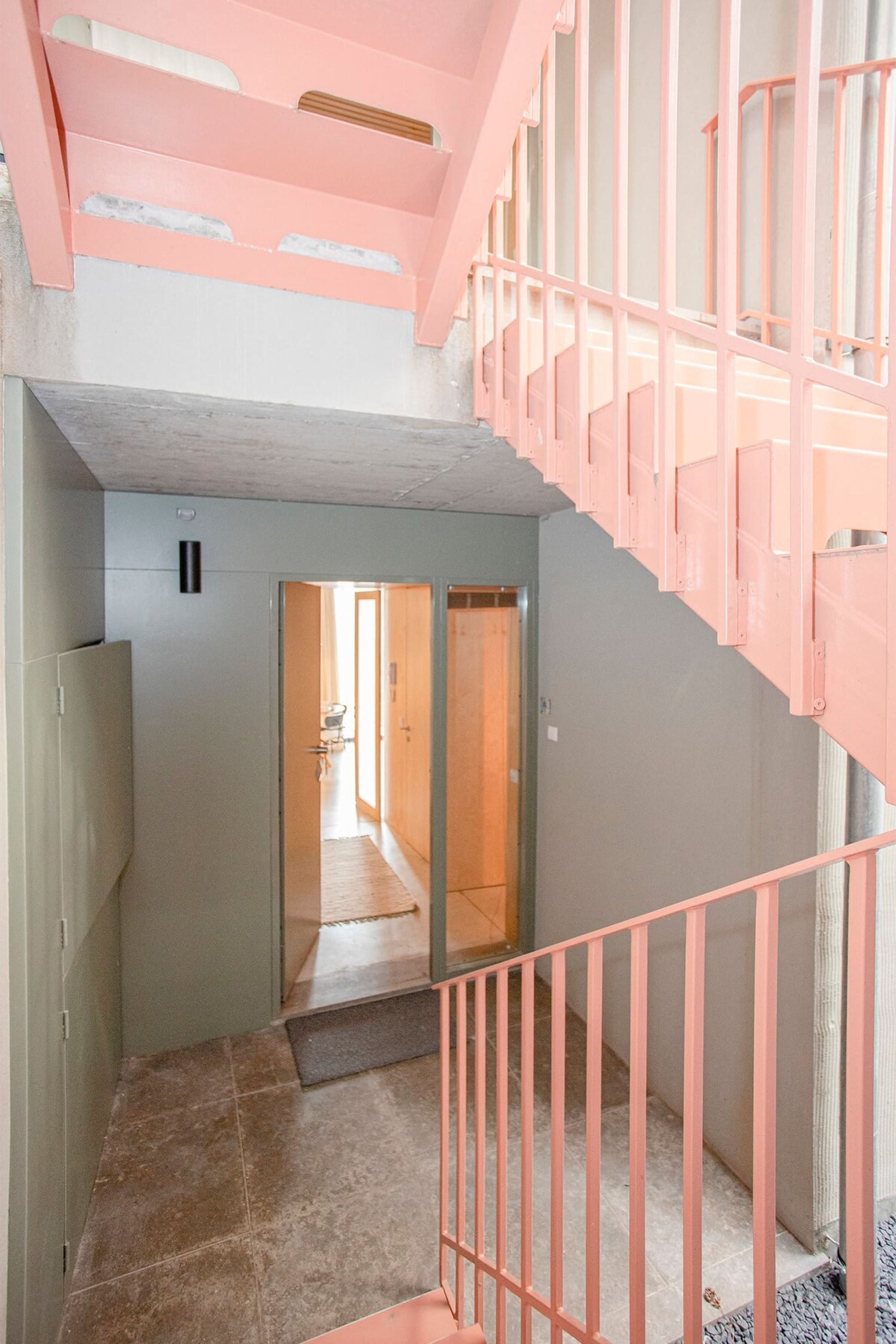 A staircase with pink railings leading to an upper level.