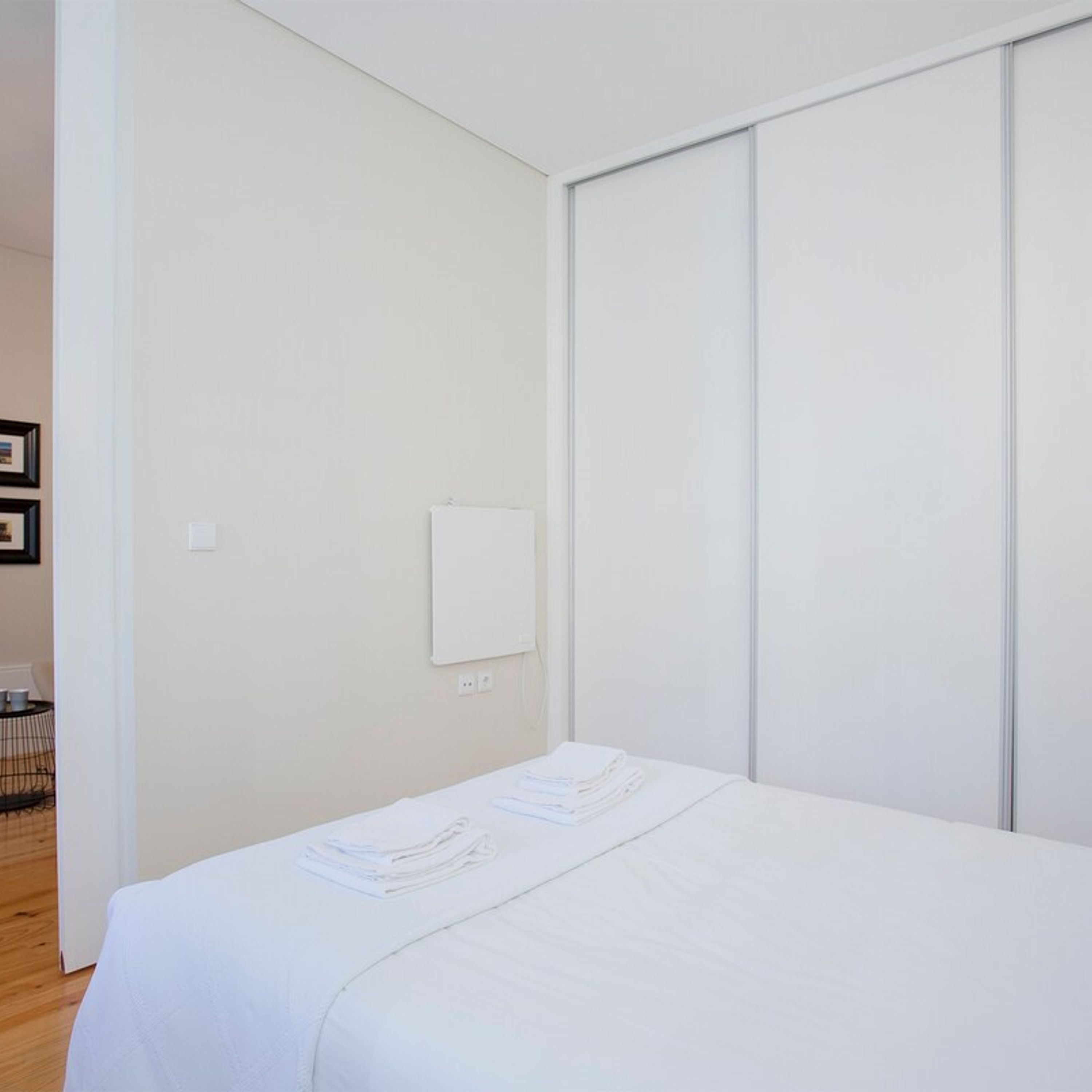 Un dormitorio minimalista con una cama, una pizarra y un armario.