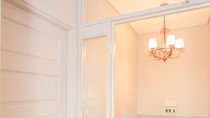 A staircase with a wooden finish, white walls, and a chandelier. - Liiiving in Porto Historic Cl Rigos Studio - 1F (Porto)