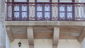 A building with a balcony featuring wrought iron railings and three windows with dark frames. - Liiiving in Porto Downtown Luxury Apartment 1R (Porto)
