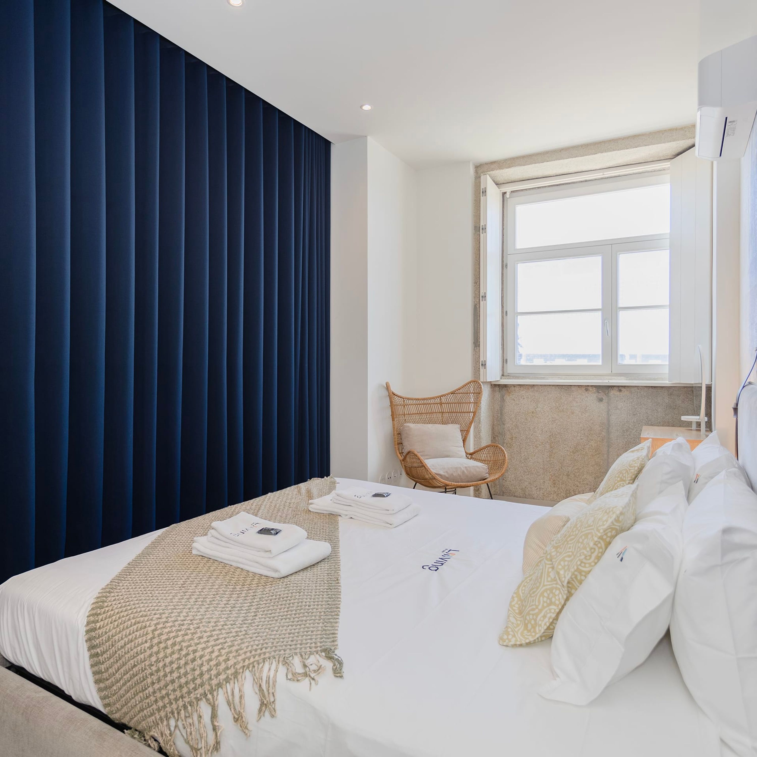 Ein modernes Schlafzimmer mit Bett, Fenster und Stuhl.