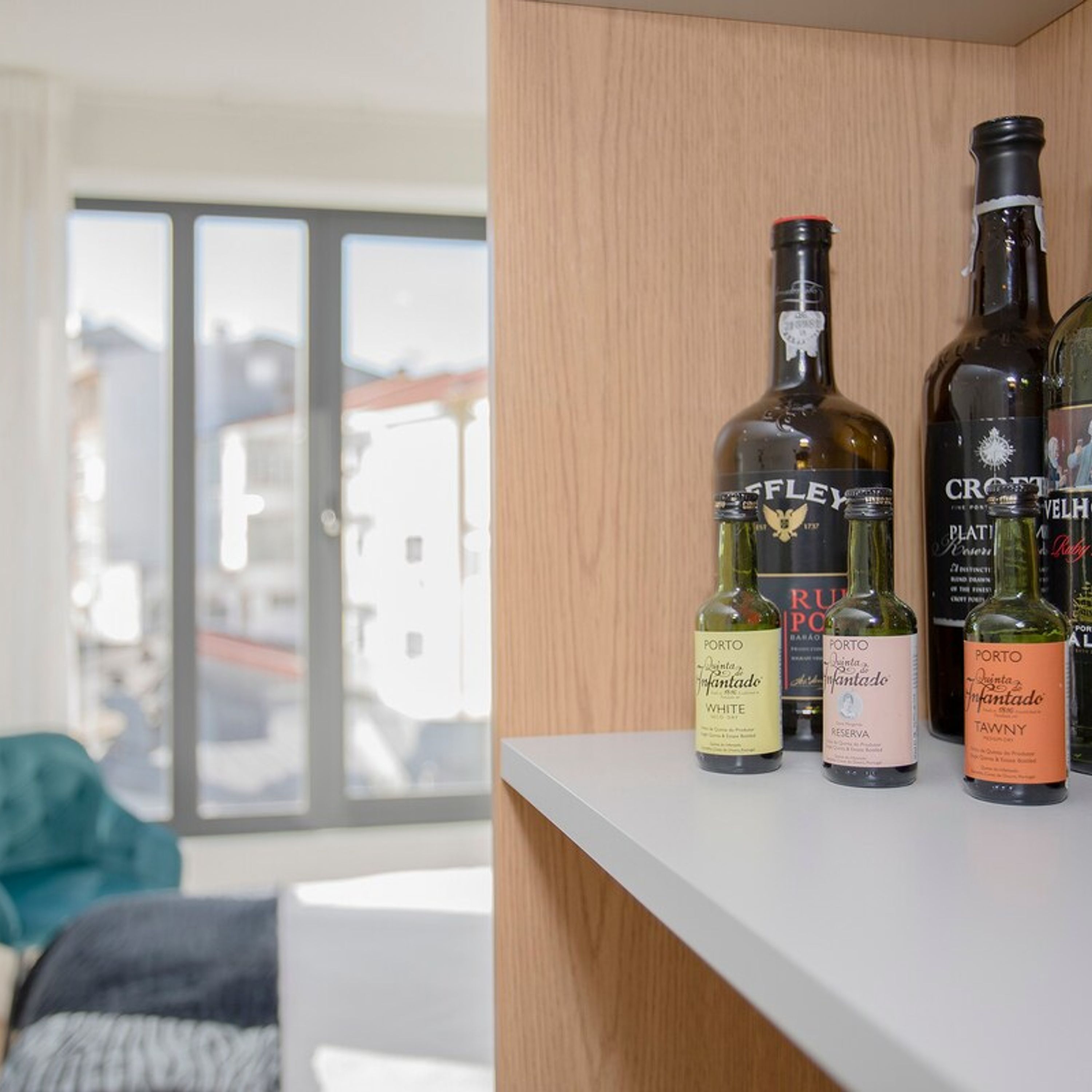 A shelf with bottles of white wine and port wine.