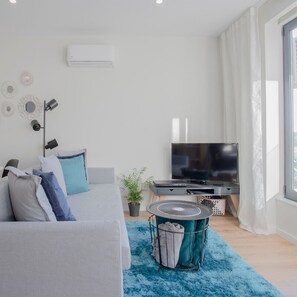 A modern bedroom with a bed, a TV, and a window. - Liiiving in Porto Bright Light Studio (Porto)