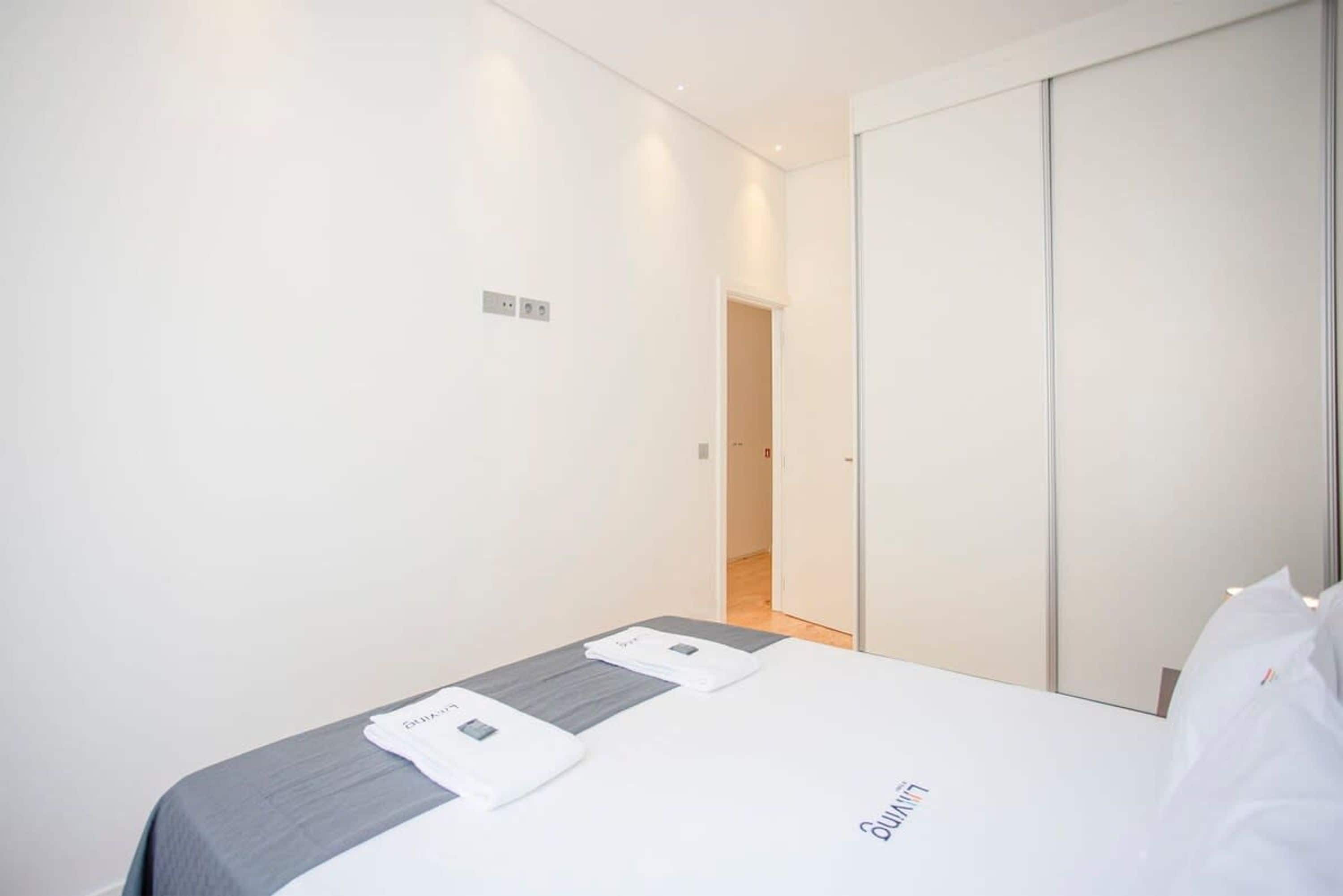 Een hotelkamer met een bed, een kledingkast en een kleine badkamerhoek.