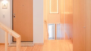 A modern interior with a wooden door, a light-colored wall, and a wooden floor. - Liiiving in Porto-mouzinho Residence Apartment 1F (Porto)