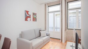 Una sala de estar moderna con un sofá gris, un televisor de pantalla plana y obras de arte en la pared.