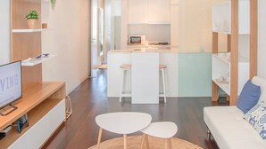 Un soggiorno moderno con TV, un'area pranzo e una cucina.