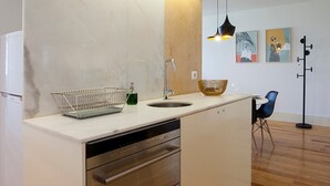 A modern kitchen with a wooden countertop, stainless steel appliances, and a pendant light. - Liiiving in Porto Central Secret Balcony (Porto)