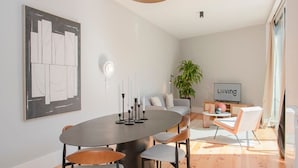 Un salon moderne avec une table de salle à manger ronde, deux canapés, une table basse et un téléviseur.