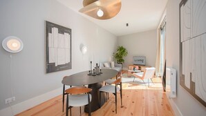 Un espace repas moderne avec une table ronde, des chaises et un luminaire suspendu.